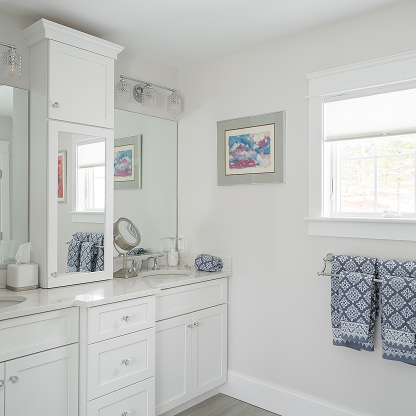 White bathroom vanity with built-in medicine cabinet and blue patterned towels