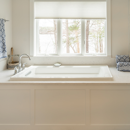 Built-in soaking tub with large window view and white paneled surround