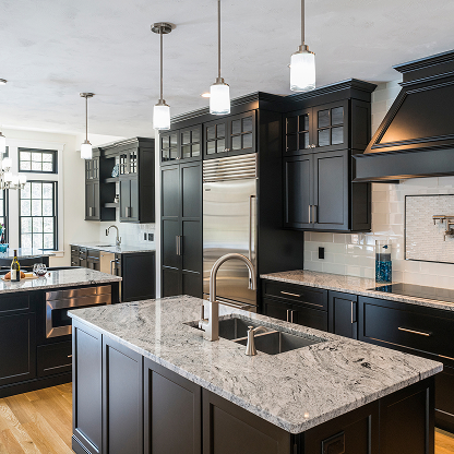Luxury black kitchen with marble countertops, pendant lighting, and stainless steel appliances