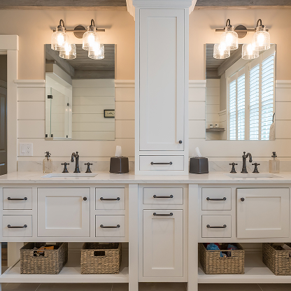 Double vanity bathroom with white shaker cabinets, storage tower, and basket storage