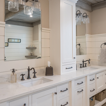 White double vanity bathroom with shiplap walls, marble countertops, and bronze fixtures