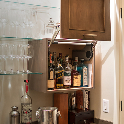 Luxury home bar cabinet with glass shelving, premium spirits collection and cocktail mixing equipment