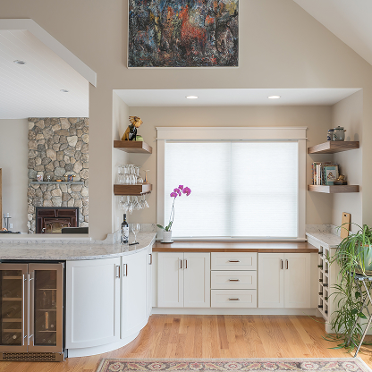 Modern white kitchen with stone fireplace, built-in cabinets, floating shelves and abstract wall art