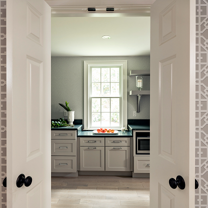 Minimalist kitchen entrance with double doors, gray cabinets and black countertops