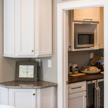 Corner kitchen cabinet with hidden pantry entrance and butcher block countertop