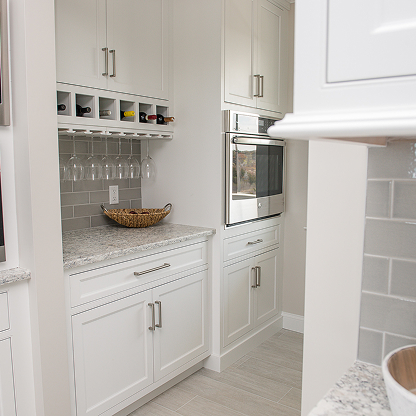 White butler's pantry with built-in wine storage, glass rack and modern appliances