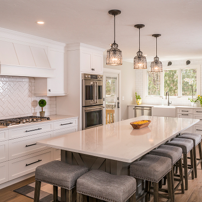 Modern kitchen with upholstered bar stools, wire cage lighting and herringbone tile