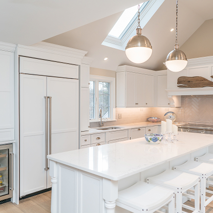Bright kitchen with skylight, white cabinets and globe pendant lighting
