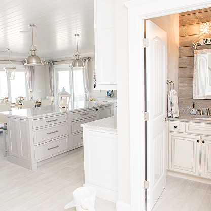 All-white master bathroom with chrome pendant lights and shiplap accent wall