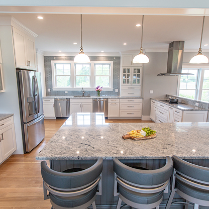 Modern kitchen renovation featuring gray granite countertops, pendant lights and breakfast bar - luxury home design