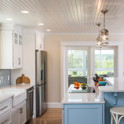 Bright kitchen design with blue accent island, shiplap ceiling and crystal pendant lights - coastal home renovation