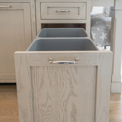 Custom pull-out trash and recycling bins in gray kitchen cabinet - hidden storage solutions