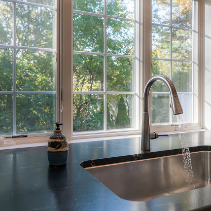 Modern undermount sink with pull-down faucet and garden window view - luxury kitchen details