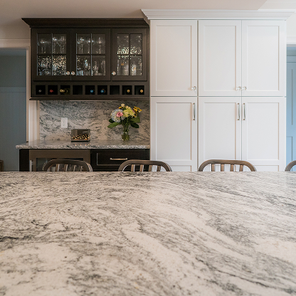Built-in wine storage and bar area with marble backsplash and custom cabinetry - luxury kitchen design