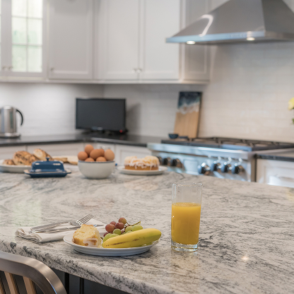 Breakfast setup on fantasy brown marble countertop with fresh fruit and orange juice - modern kitchen lifestyle