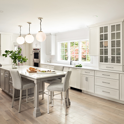 Bright white kitchen with globe pendants, glass cabinets and built-in dining area - luxury renovation