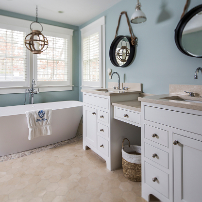 Spa-like master bathroom with freestanding tub, orb pendants, and seafoam green walls