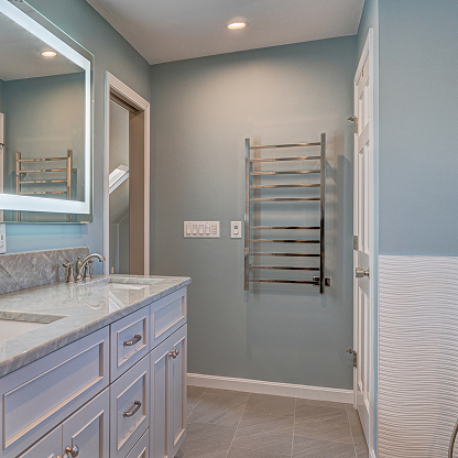 Gray bathroom vanity with heated towel rack and marble countertops