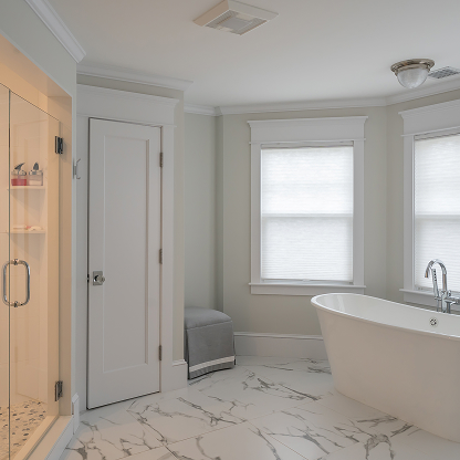 Modern master bathroom with freestanding tub, marble floors, and glass shower enclosure